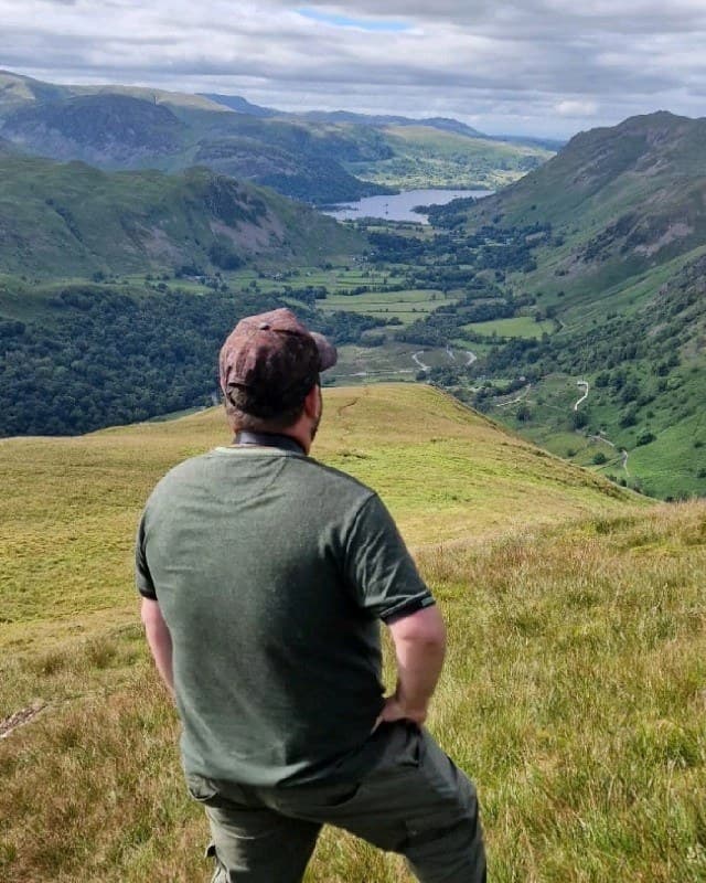 Nathan Green of GEM Services, seen from behind, looking out over a valley
